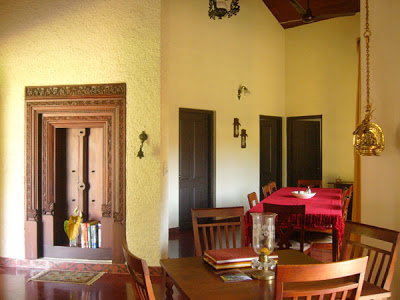 The dining area is decorated with hanging brass lamps, nooks and crannies, and a lovely old ornamental door