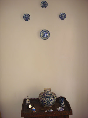 the bell and blue pottery collection displayed on a Kashmiri walnut tea trolley
