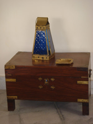 An old wooden treasure chest, with a brass and glass decorative lantern