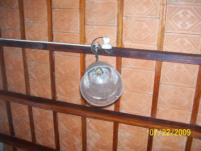 A Mangalore-tiled roof with rafters and an antique light bulb