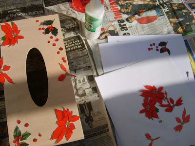 Arrange the cut out poinsettia pictures on the tissue box