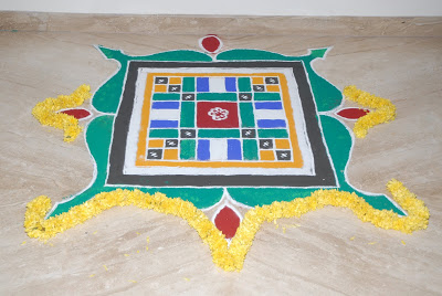 The house is decorated with flowers and beautiful rangolis