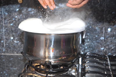 the stove is lit with a container filled with milk