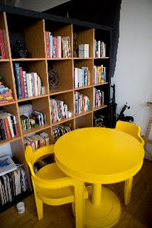 Bookshelf and yellow table and chair at the study room