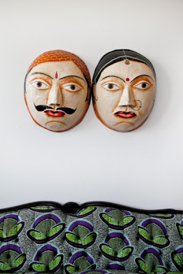 The two paper mache masks hanging on the wall
