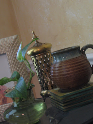 The brass, greenery and the earthen pot form a perfect combo in the living room