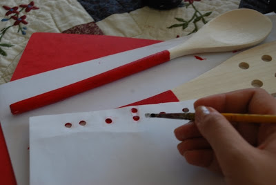 Place the hole paper on the wooden spoons and paint over it.