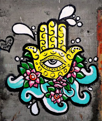 the symmetrical Khamsa with an eye on its palm surrounded by lotuses, waves and seafoam