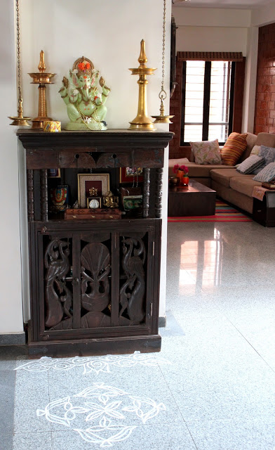 book shelf with brass accessories and rangoli | Deepa and Sriram's Summer Decor