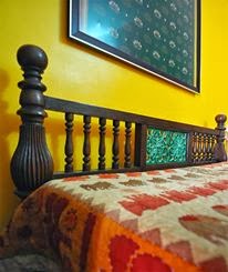 master bedroom, tile inlay on old bed, yellow wall, accent, fabric on wall