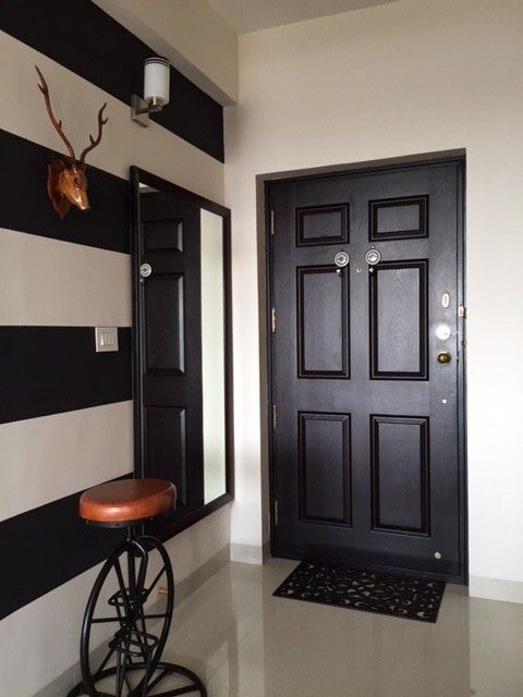 The foyer is minimally done up with a Coco-Chanel wall, stag horn and cycle stool