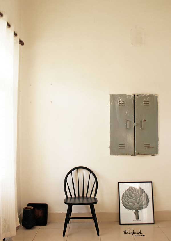The switchboard was deliberately left unpainted, and unconcealed, and the painting and chair come together to make a stark yet effective style statement