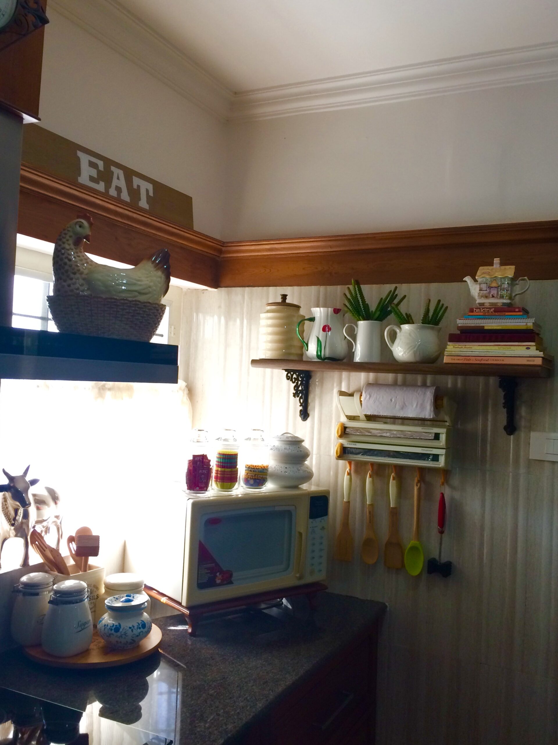 A lovely corner of the kitchen, in contrast to the seek cabinetry and glass shelves | Joseph home tour