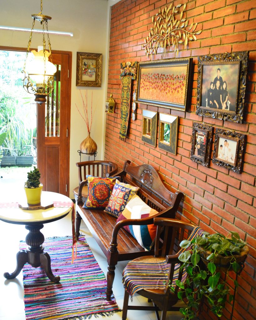 A brick wall and colonial furniture greet visitors at the entry way | Inda and Sony Sulaksono's Colorful Home tour