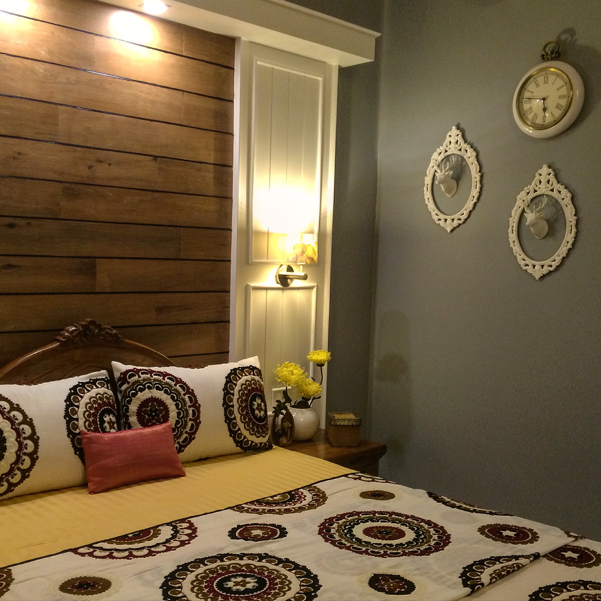 The guest room are decorated with frames on the wall with the beautiful deer heads on it, the embroidery on the bed covers and grey wall | Joseph home tour