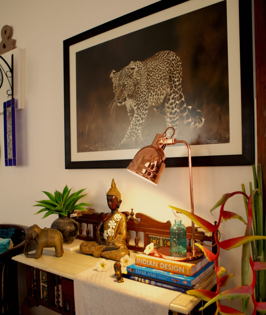 The leopard is a photograph taken by Zhayynn James and the brass elephant on the console at the corner of the living room | Sujatha and Bharath's Apartment decor - Home tour