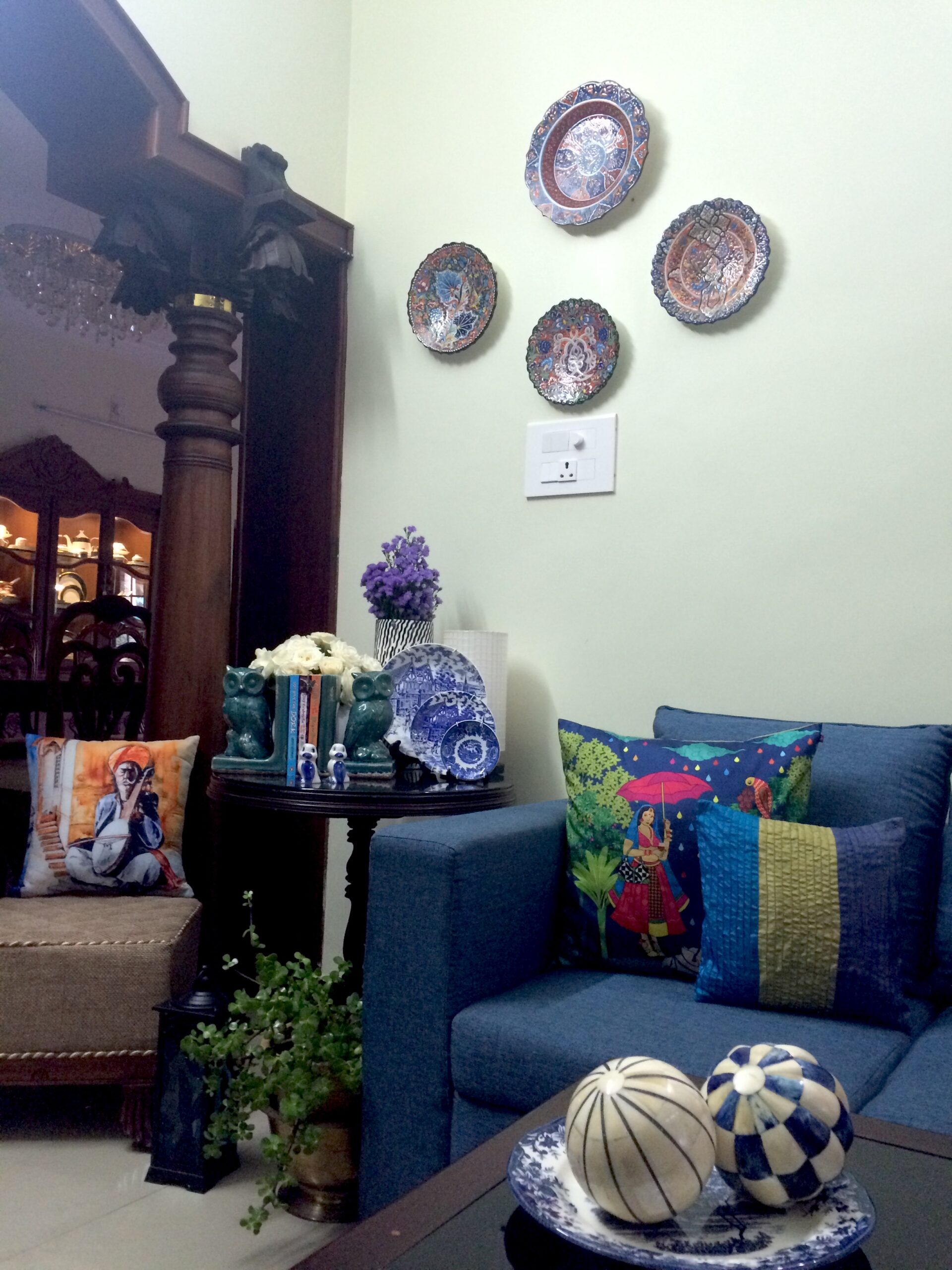 The blue room is decorated with blue wall plates, lanterns, blue sofa, green plants, cushion covers and antique wooden pillars | Joseph home tour