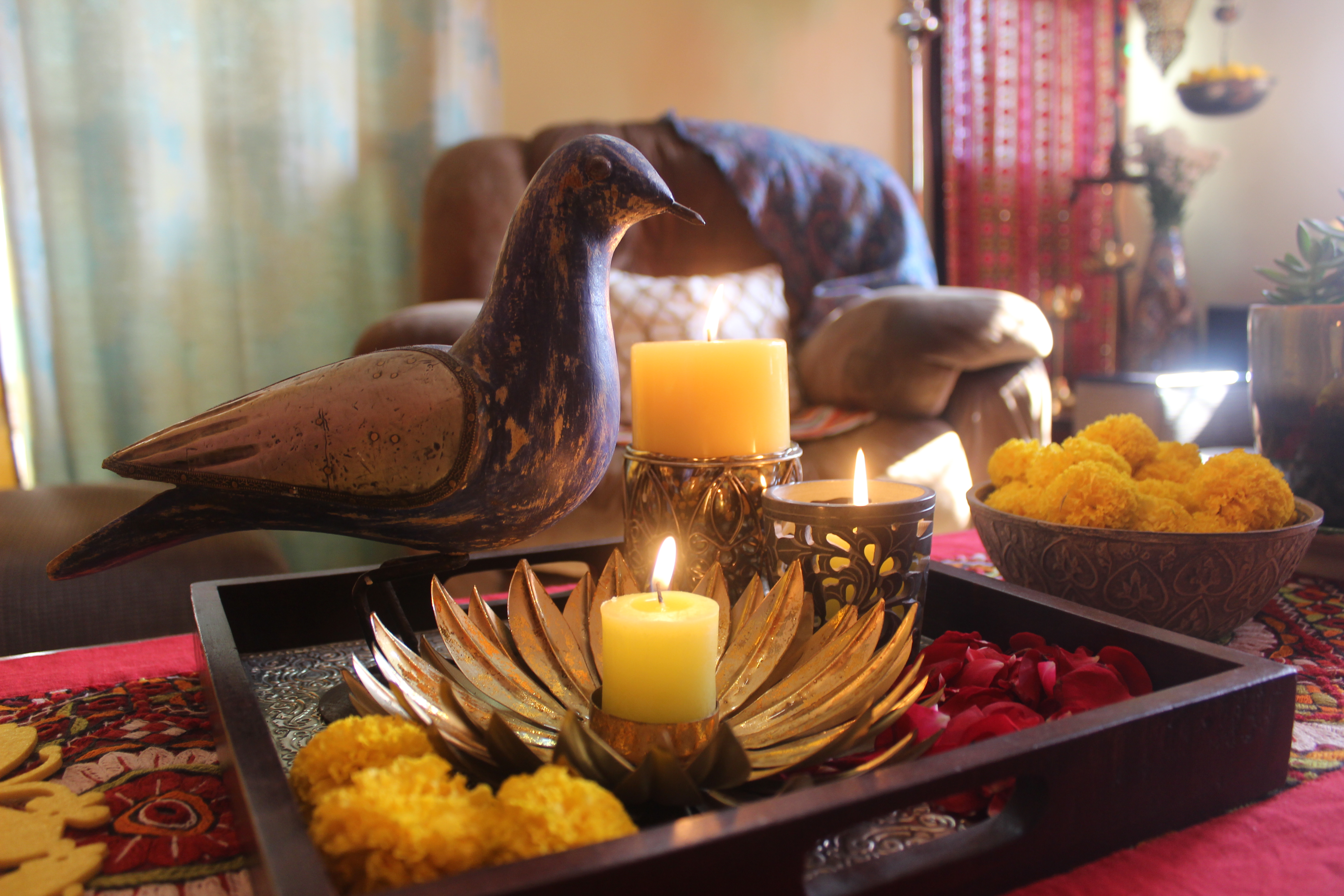 Wooden bird and brass candle holder at the living room table | Color and dramatic at Bembem's Pune Home