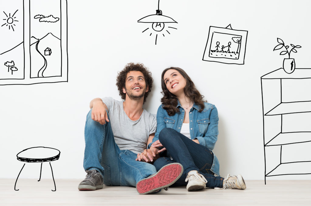 happy couple sitting on the floor thinking of a home renovation