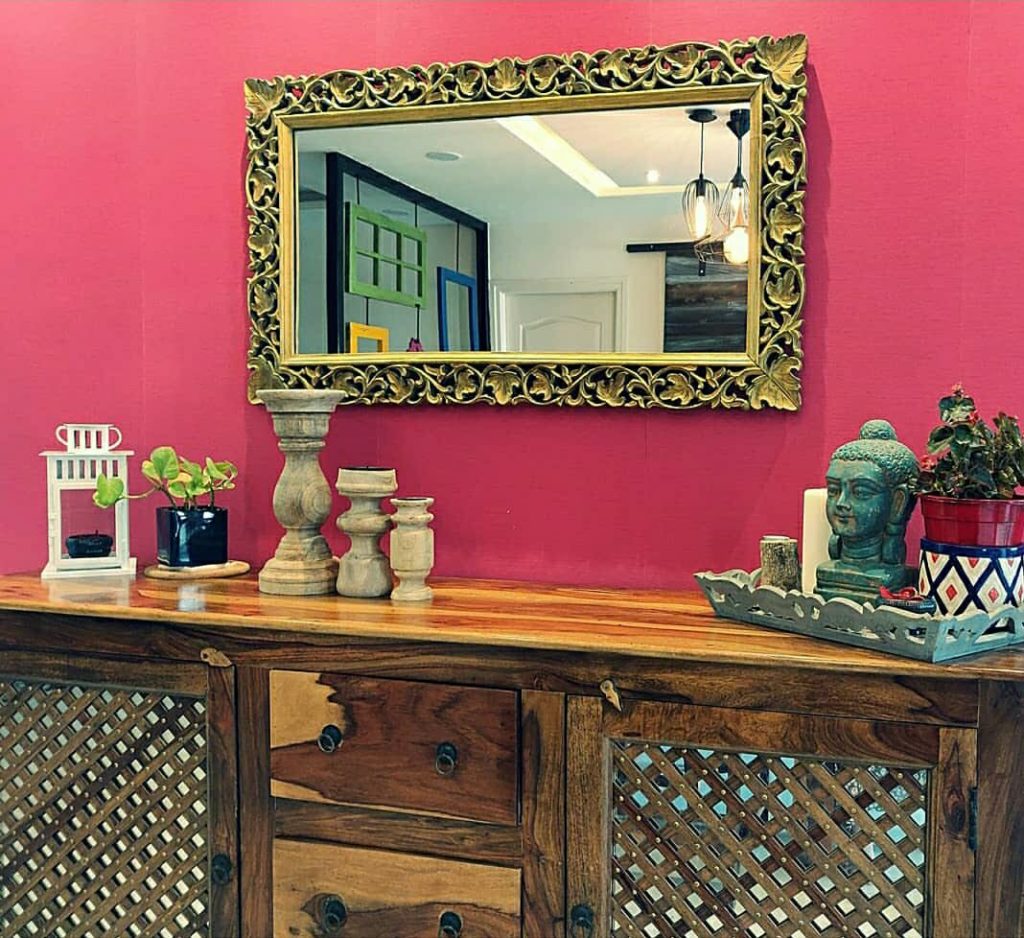 Home style Tour with Rajni in Hyderabad: the collection of candle holders, plants and vintages on the cabinet and decorative mirror makes the room beautiful