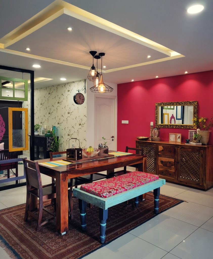 Home style Tour with Rajni in Hyderabad: the dining room is filled with beautiful colorful frames, green plants, decorative mirror, cabinet and vintages