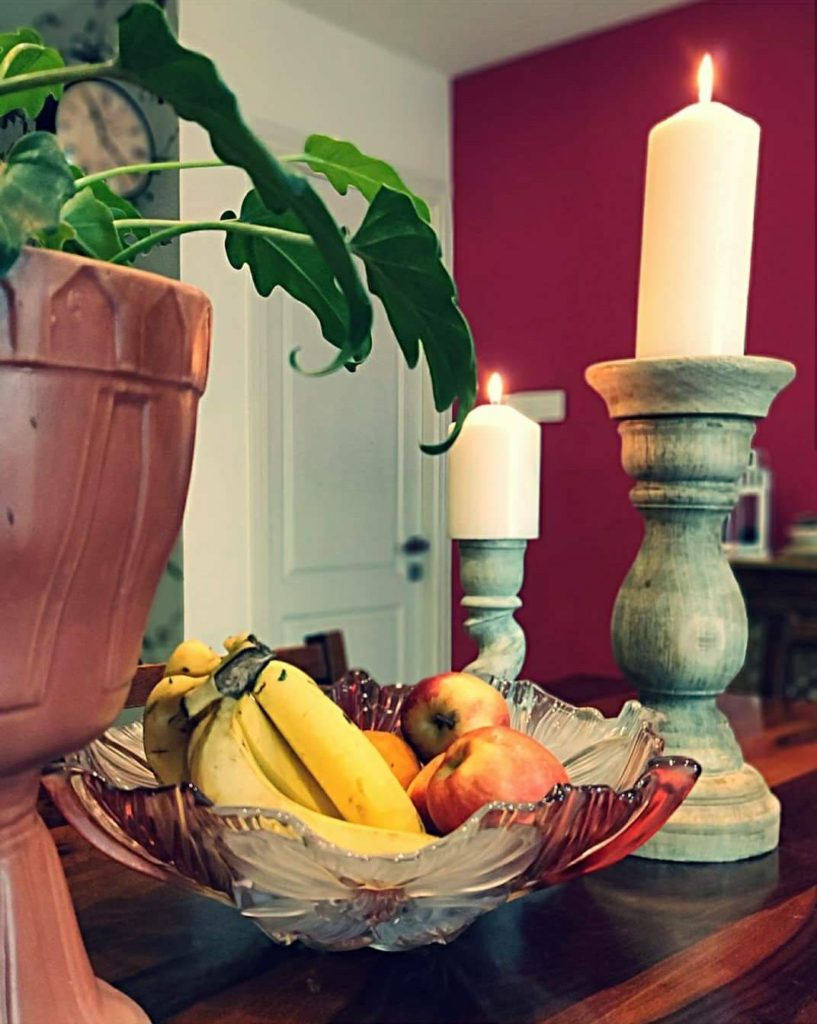 Home style Tour with Rajni in Hyderabad: the dining table filled with green plants, the beautiful candles stand and fresh fruits 