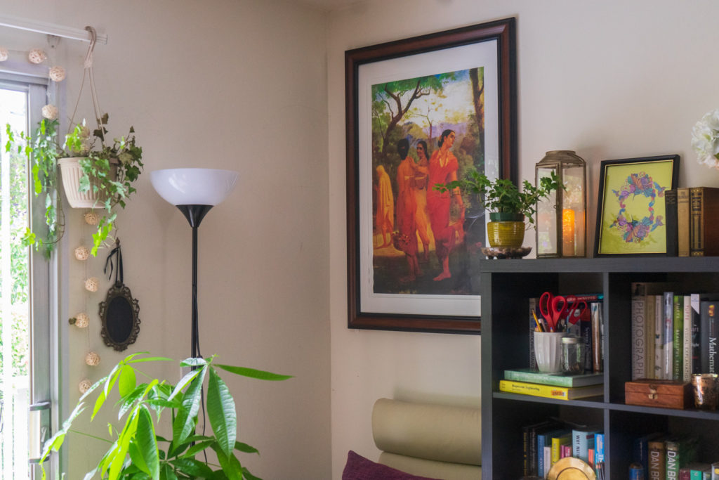 Affinity for antiques and collection of vintage | Home tour of Rushika & Dipkal's - the oil painting, indoor green plants, candle stand, book shelf and vintages at the living room