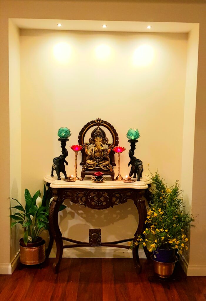 Mixing lotus candles, god ganesha, elephant candle holders, green plants and fresh flowers makes the puja room look bright and beautiful