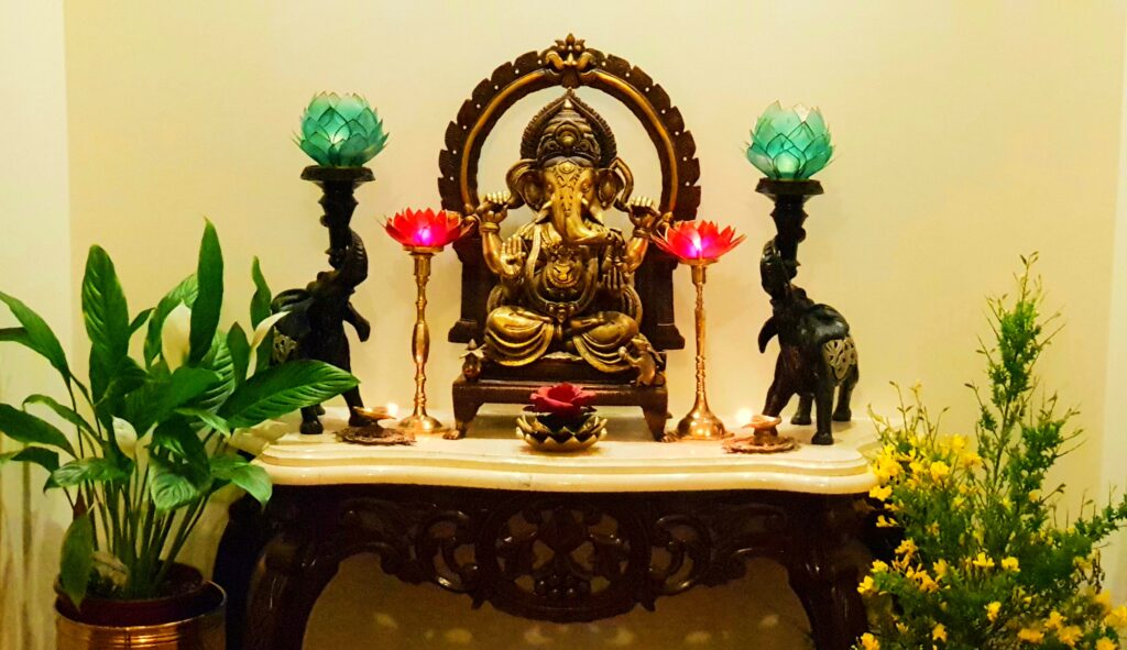 Mixing lotus candles, god ganesha, elephant candle holders, green plants and fresh flowers makes the puja room look bright and beautiful