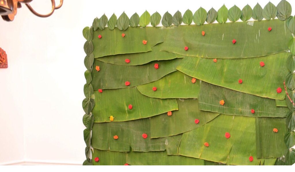 The banana leaf with fresh betel leaves on the sides, decorated on the wall