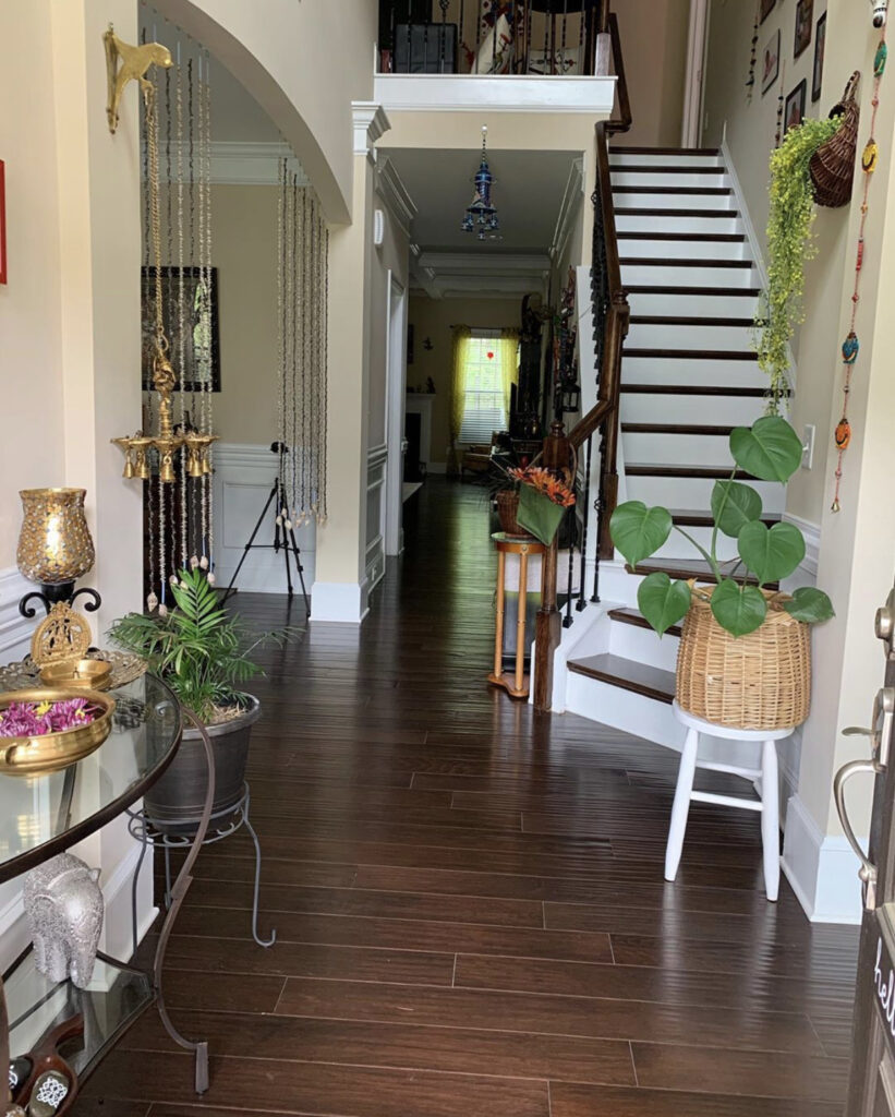 The staircase is decorated with photo gallery on the wall and green plants