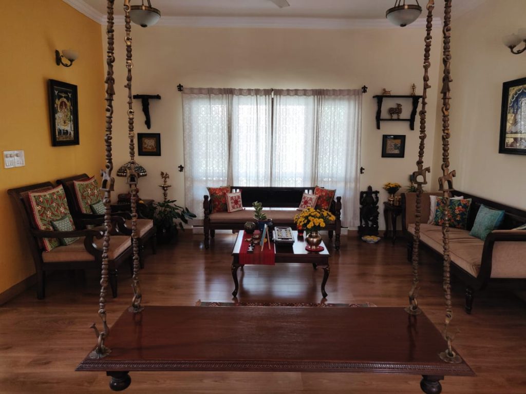 The living room is filled with vintage, brass collection, wall frame, and also indoor swing