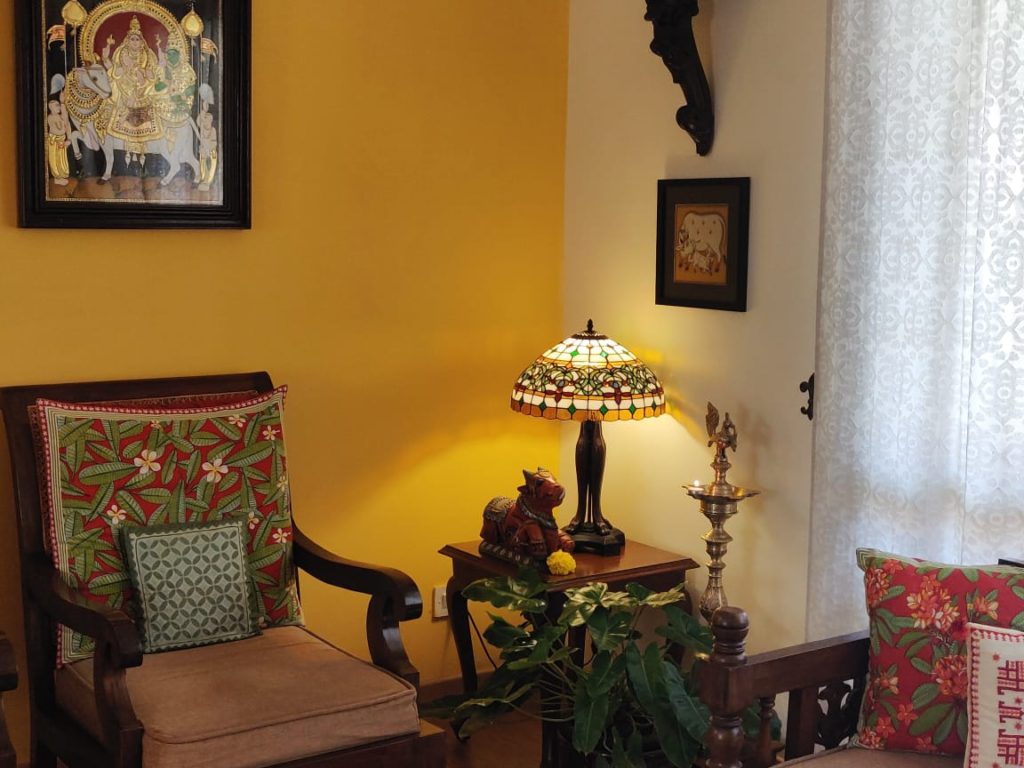 diya brass, lamp, bull sculpture, wall frames and green plants decorated at the corner of the living room