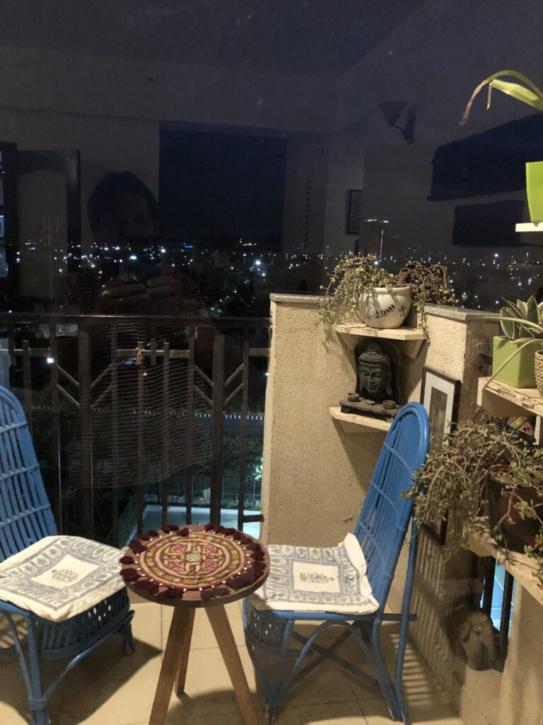 balcony seating, blue chairs, city view, indian apartment decor, n