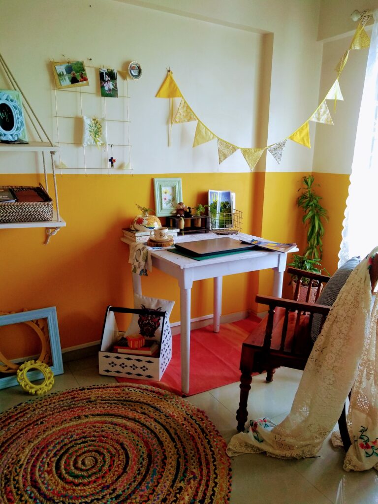 the bright yellow half painted wall, and an old dining table in white | home office set up