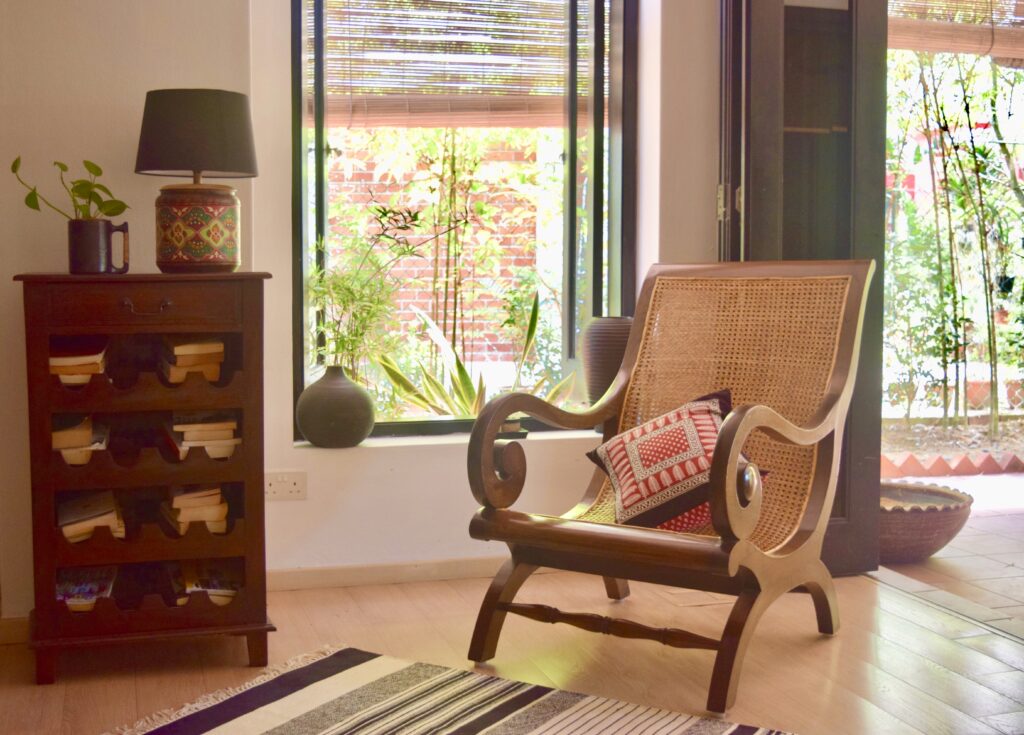 The family room is decorated with chair, green plants and book shelf | ASHA RAJ home tour