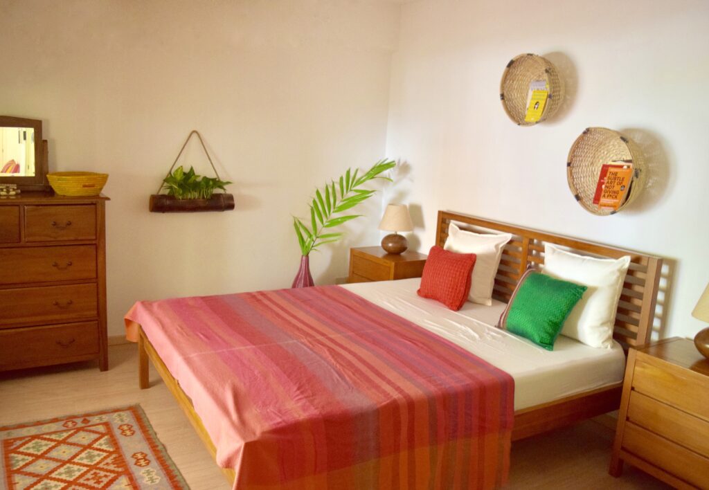 The guest bedroom area is decorated with wall baskets used as mini book holders, green plants and drawer chest | ASHA RAJ home tour