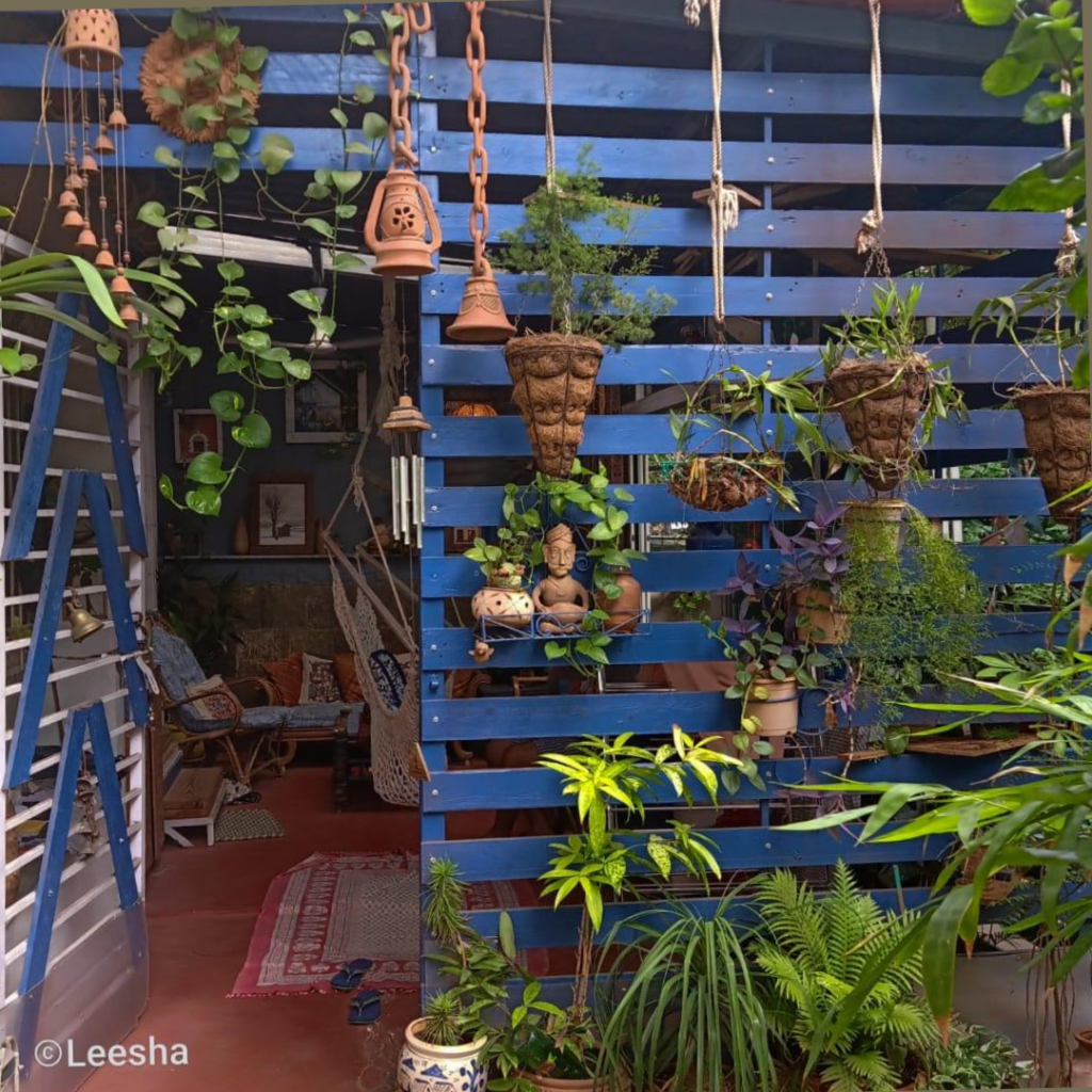 The assortment of lamps and terracotta bells at a blue slatted structure is decorated outside seating area | Leesha's Pune home | Thekeybunch