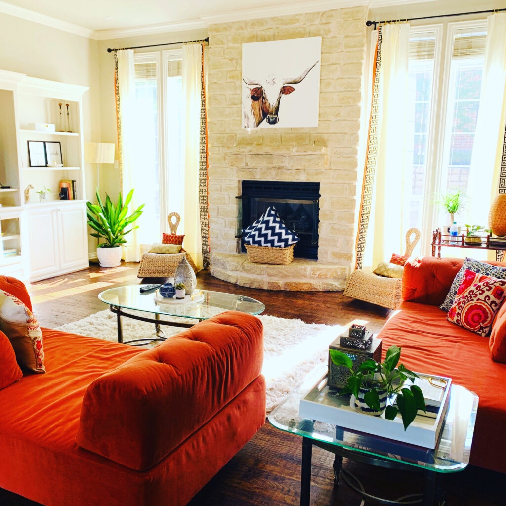 the living room is decorated with orange sofa, green plants and art on the wall | Ruma's Indian Home in Texas | theKeybunch decor blog