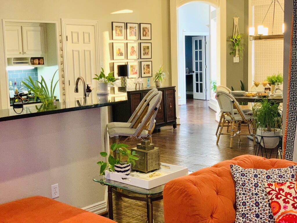 the room is decorated with wall gallery, green plants, vintages and orange chair | Ruma's Indian Home in Texas | theKeybunch decor blog