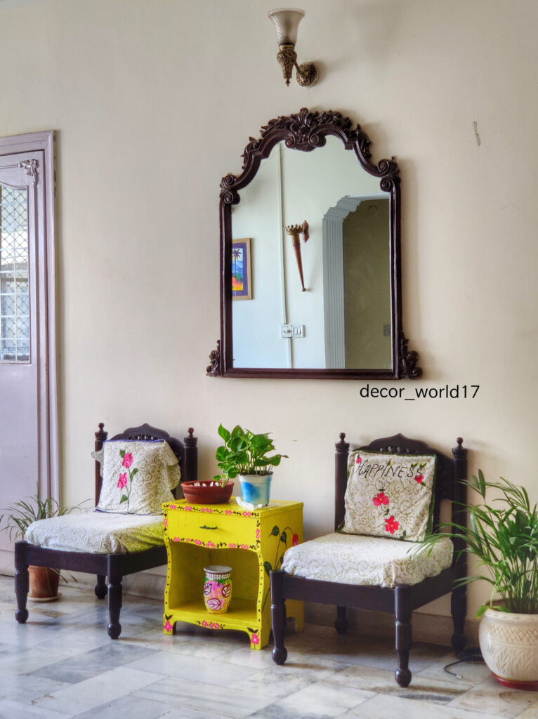 The corner of the room is decorated with antique chairs, yellow table, green plants and  decorative mirror | Dharitri home tour | thekeybunch decor