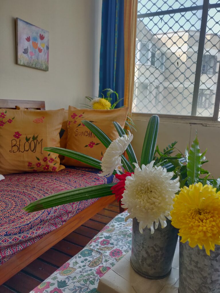 Handpainted cushion covers, art frame and fresh flowers make the room look bright and beautiful | Dharitri home tour | thekeybunch decor