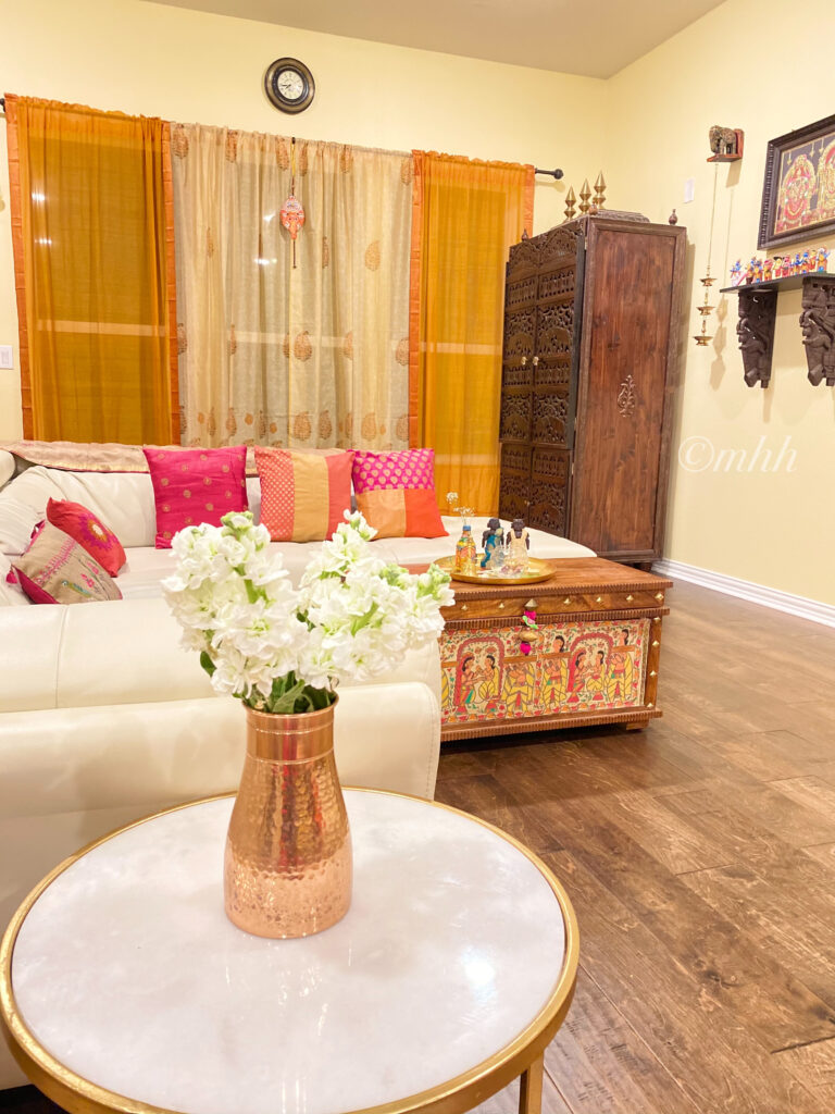 Home tour of Meena Harish | The living room has a distinct Indian vibe. Colourful sheers carved wooden pieces, and a colourful chest that doubles up as a coffee table.