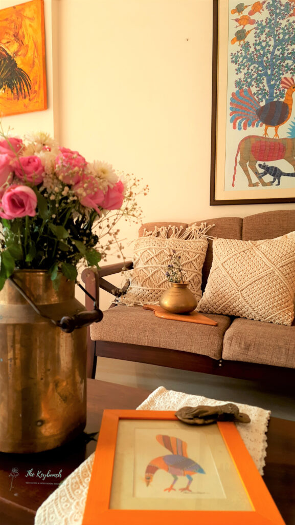 The living room is styling up with macrame cushion cover, dry plant on brass vase, rose in a vintage milk can, wooden frame on table and frame on wall | Areas where an Interior Stylist can help you | Thekeybunch decor blog