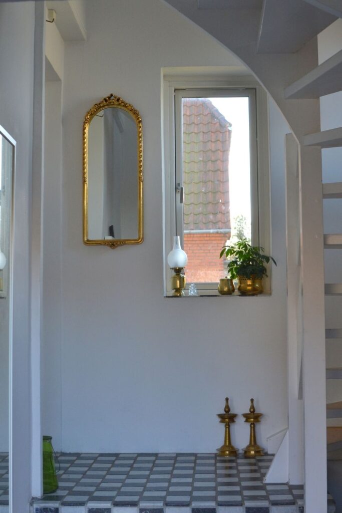 The gold mirror and vintage brass collection at the corner of the room | Naina's Scandi-Minimalist Home with Indian Accents