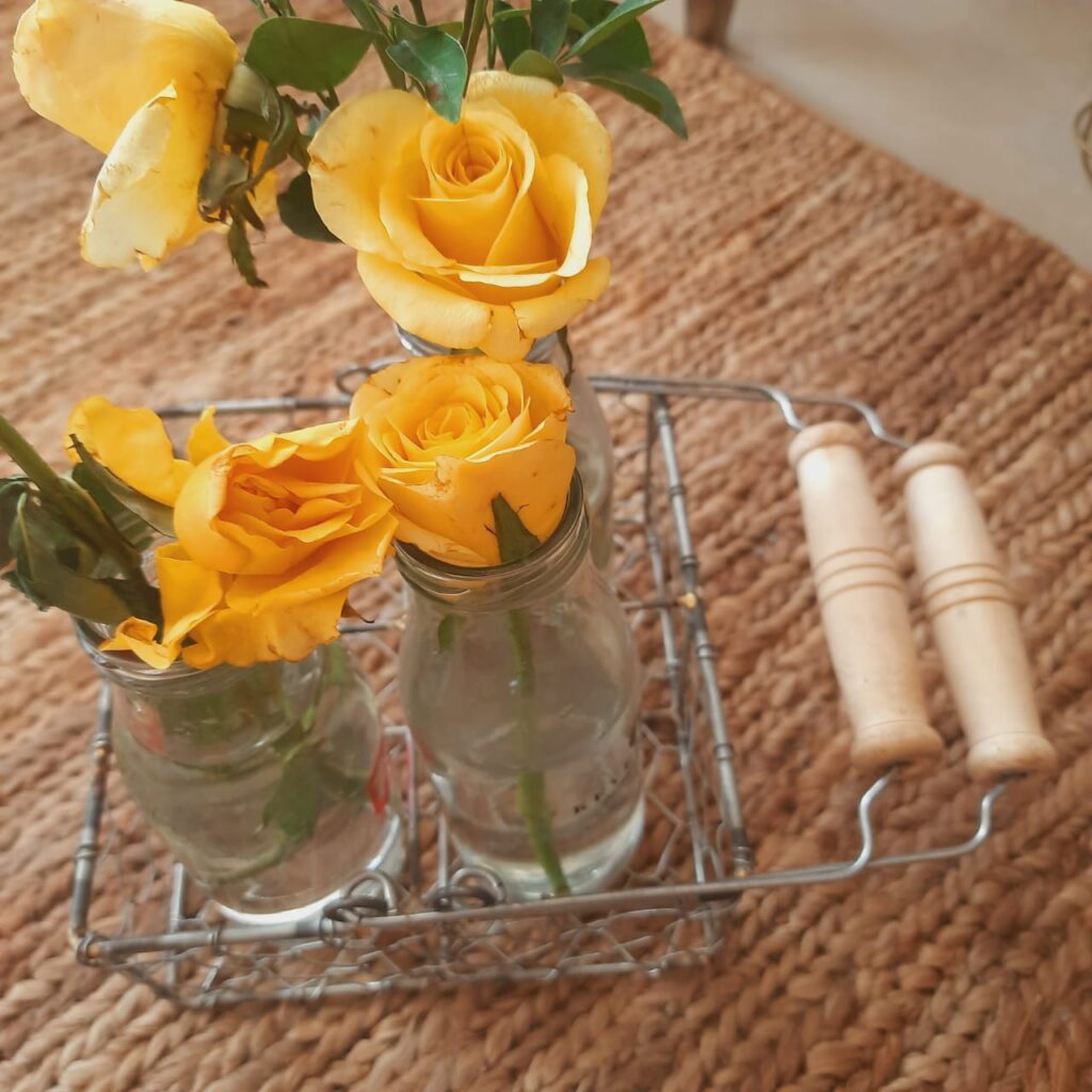 Reused the wire caddy basket as an interesting flower holder, using 4 bottles to hold flowers | A case for Baskets | TheKeybunch decor blog