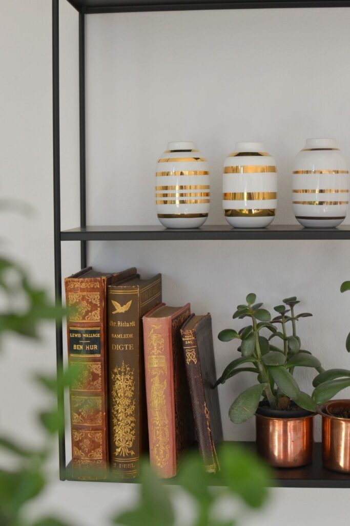 The vintage books, brass planter filled with green plants and miniature vases | Naina's Scandi-Minimalist Home with Indian Accents