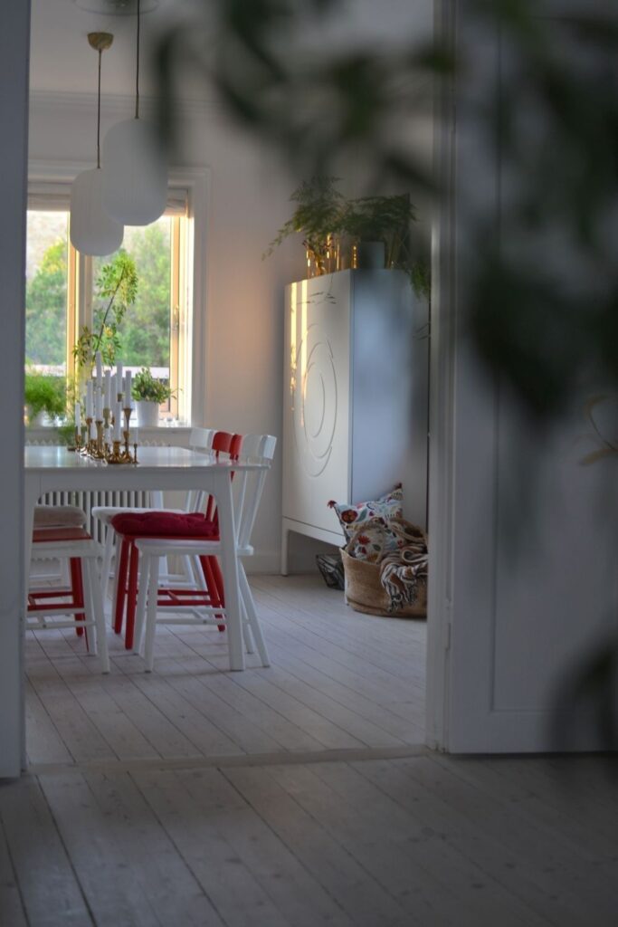 The dining room in red and white chair, golden candle holder and sun light kissed from the window | Naina's Scandi-Minimalist Home with Indian Accents