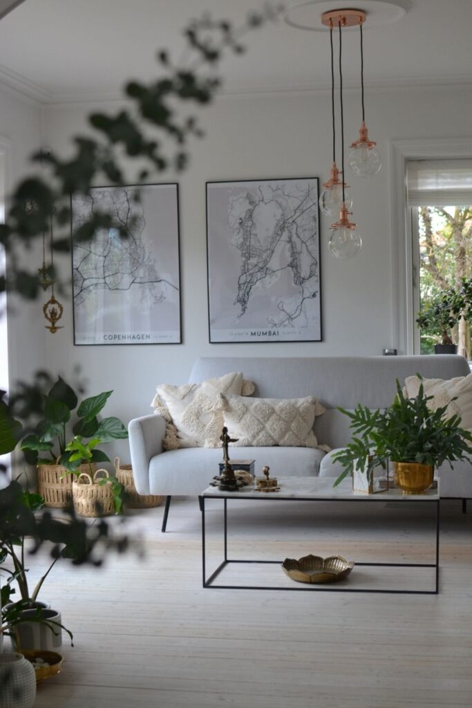White living room decorated with green plants, hanging lights, wall map frame and basket planter | Naina's Scandi-Minimalist Home with Indian Accents