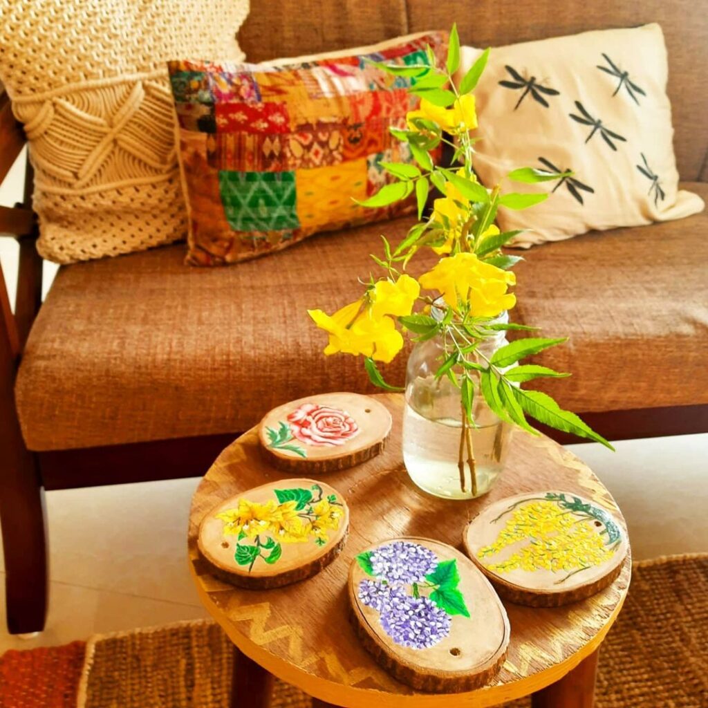 Decorate with a touch of yellow during the pandemic | A colourful cushion cover with some small patches of yellow, along with coasters painted with yellow flowers